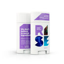 Two sticks of natural deodorant from the brand Rise, one with a purple cap and one with a white cap. The packaging promotes the product as being aluminum-free, paraben-free, and cruelty-free.