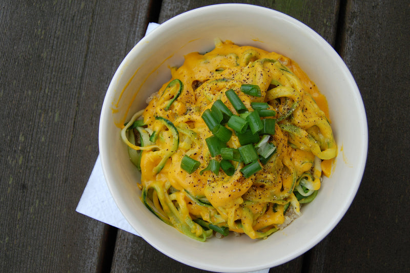 Creamy vegan mac n' cheese served in a bowl with fresh herbs