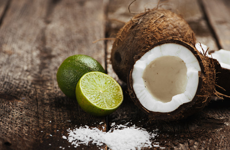 Close-up of raw coconut lime macaroons, topped with shredded coconut and zesty lime, arranged on a white plate for a fresh, tropical dessert presentation.