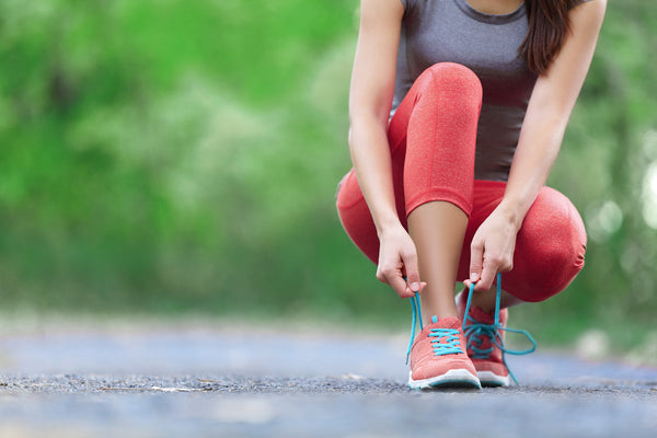 Woman tracking fitness goals on a journal to stay motivated with New Year’s resolutions