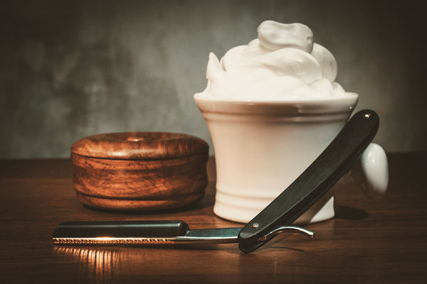 DIY shaving cream in a bowl with a creamy texture, surrounded by natural ingredients, promoting silky smooth skin.