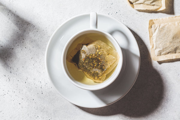 Cup of chamomile tea with steam rising, symbolizing relaxation and stress relief.