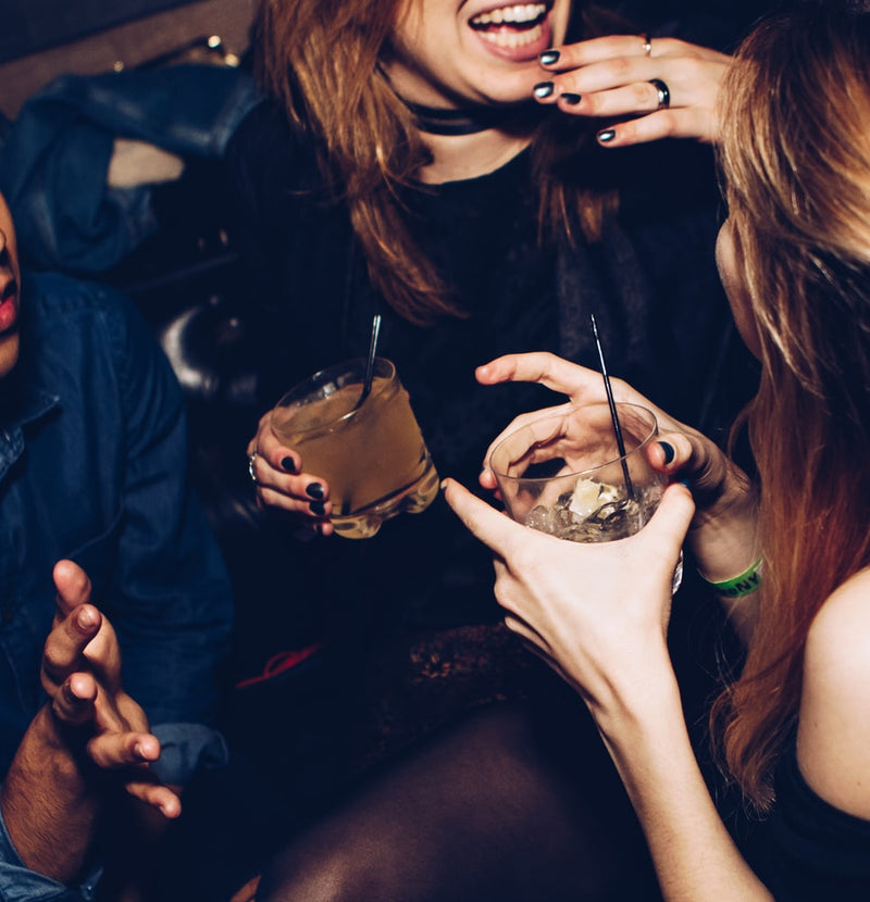 Assorted vitamins and supplements on a table with water and fruit, highlighting natural remedies that help relieve hangover symptoms.
