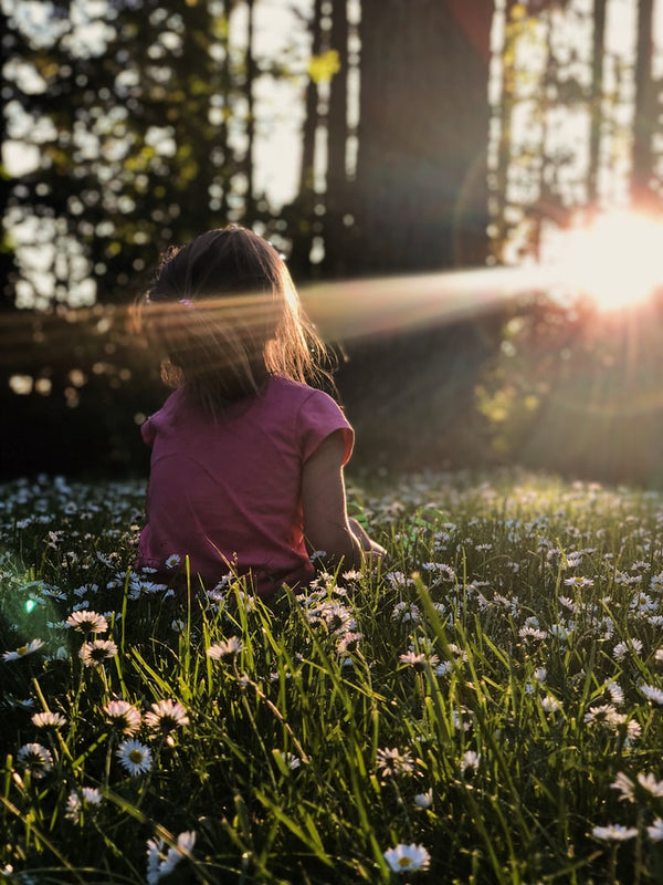 Child practicing mindfulness with eyes closed and hands on heart, promoting calmness and emotional awareness.