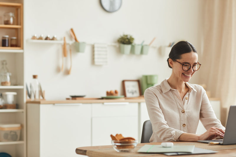 A person working from home at a tidy desk, practicing mindfulness with a cup of tea nearby, natural light coming in through the window, surrounded by plants and motivational notes, illustrating tips for improving mental health.