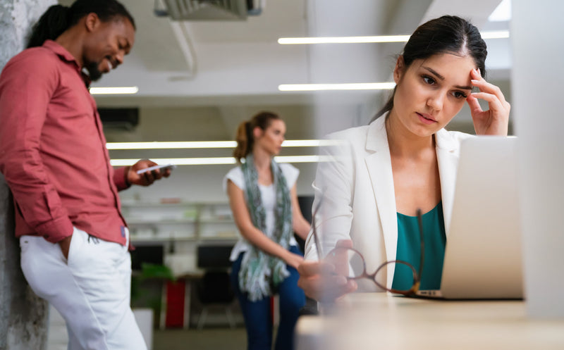 Employee practicing deep breathing exercises at work desk to reduce stress