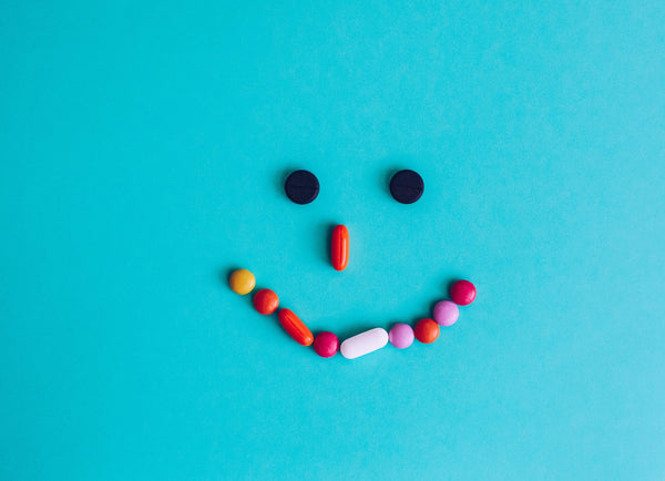 Close-up of assorted vitamin capsules and herbal supplements labeled for stress relief and anxiety support on a white background.
