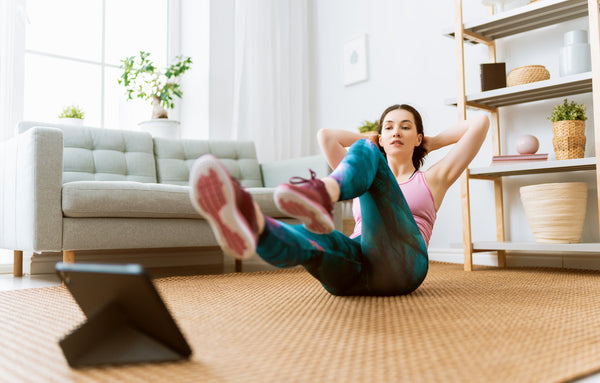 Young woman tying her running shoes in the morning, smiling and ready for a workout, symbolizing tips and tricks to stay motivated to exercise.