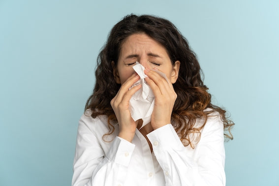 Vitamin C, collagen, and omega-3 supplements arranged on a wooden table to help fight seasonal allergies naturally.