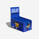 Mid-Day Squares Crunchy Peanut snack bar unwrapped, showing a rich chocolate coating with visible peanut chunks on a rustic wooden table.