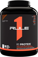 A container of Rule One R1 Protein powder in Chocolate Fudge flavor.