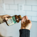 Flora DHA supplement bottle with vegetarian algae capsules spilling out, emphasizing plant-based omega-3 nutrition.