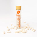 A bottle of Nudora probiotic supplements with several capsules scattered in front of and to the side of the bottle against a white background.